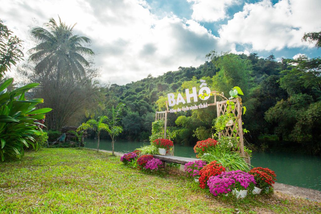 Biển nhận diện Khu du lịch sinh thái Ba Hồ bên hồ nước và cây xanh